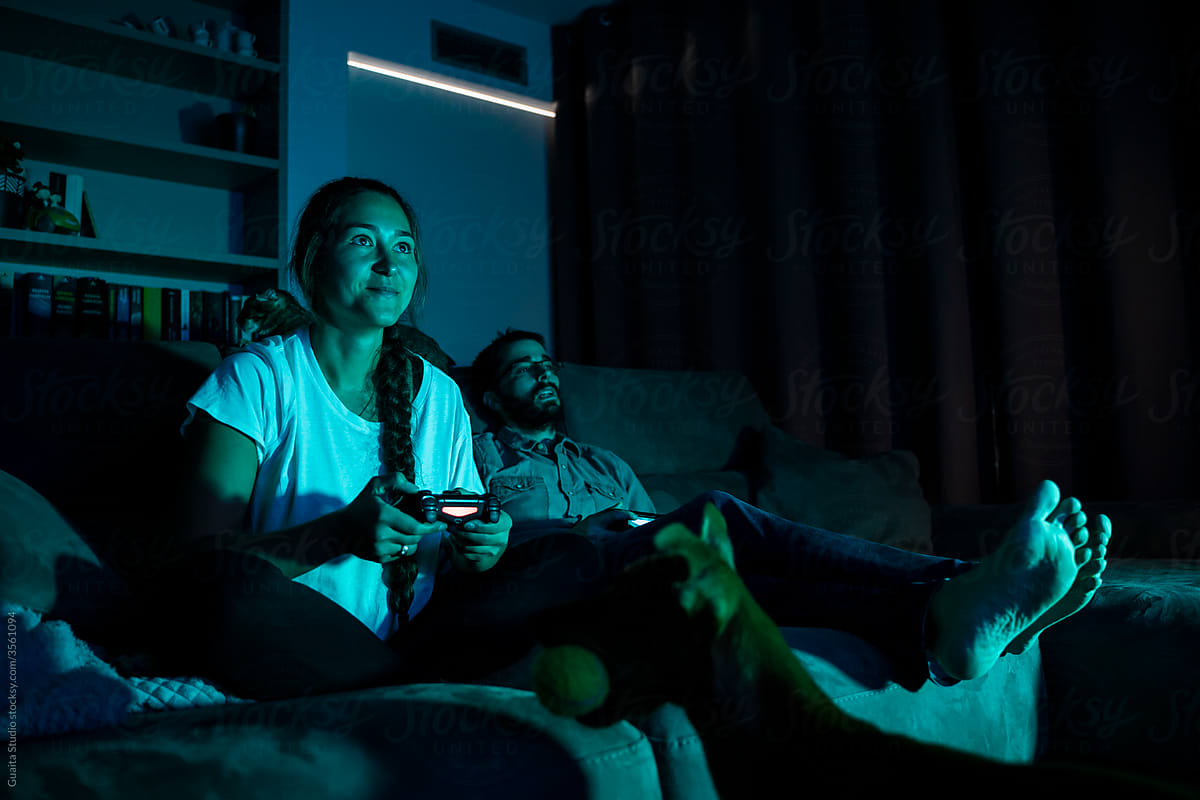 Happy  couple playing videogames at night having fun