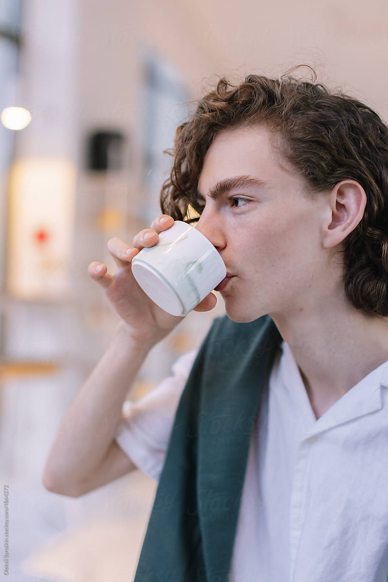 Young Guy drinking coffee in cafe