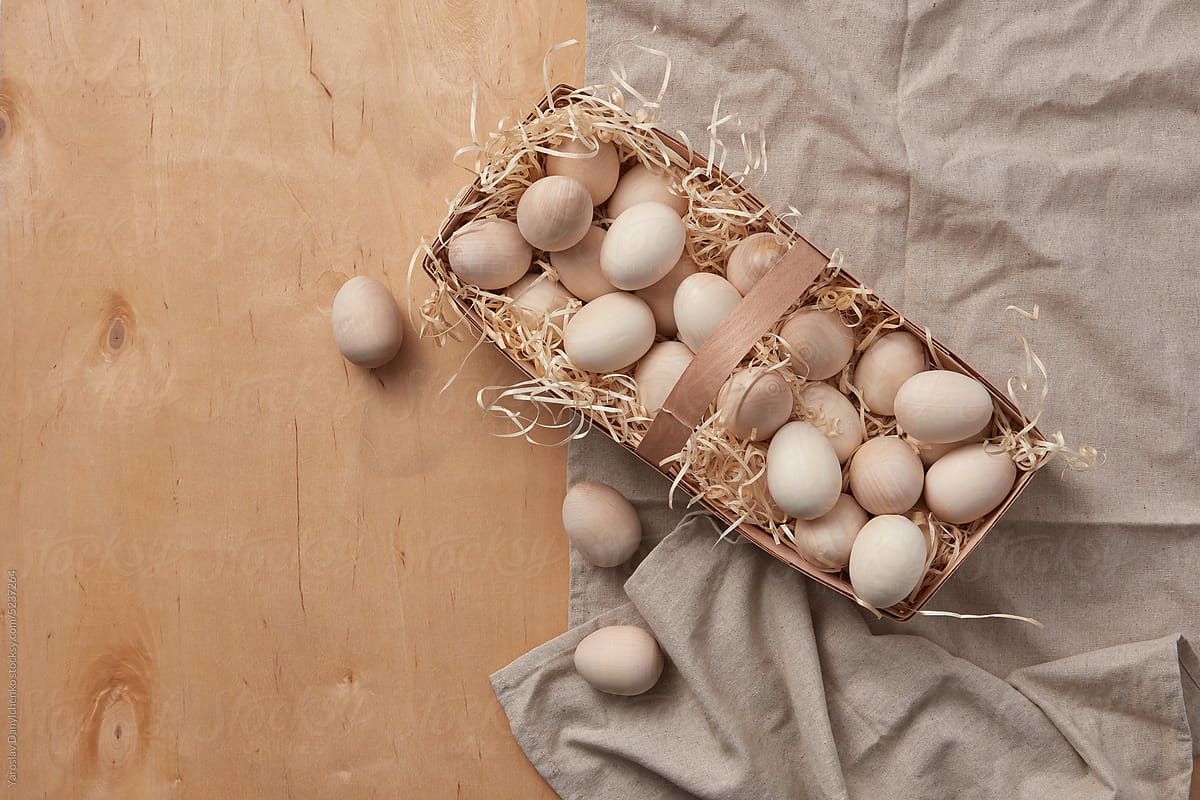 Handmade Easter eggs from wood in birch basket.