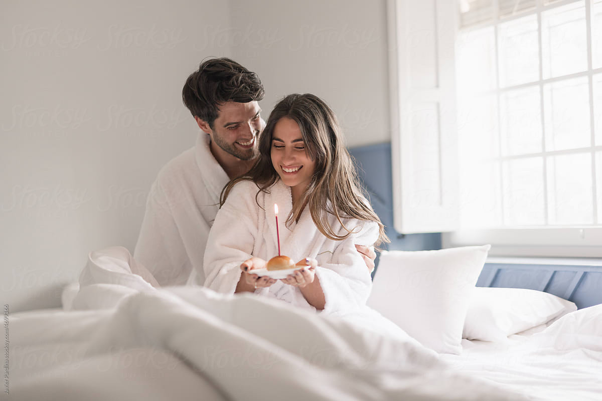 Young beautiful couple in bed giving a surprise