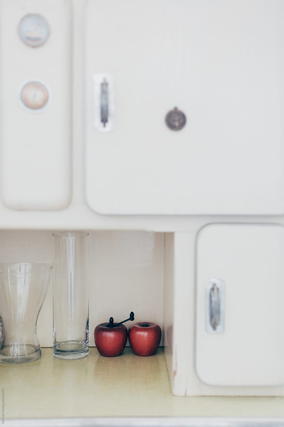 Two red apples in a kitchen cabinet
