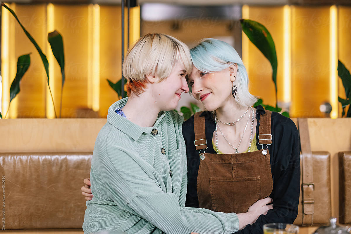 Lesbian couple hugging each other over lunch