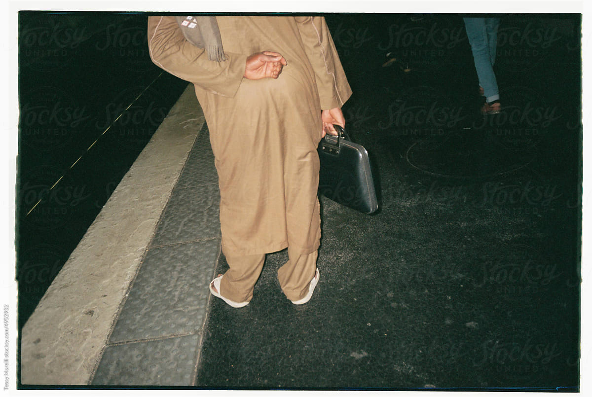 Anonymous businessman in train station with briefcase  by Tessy Morelli for Stocksy United