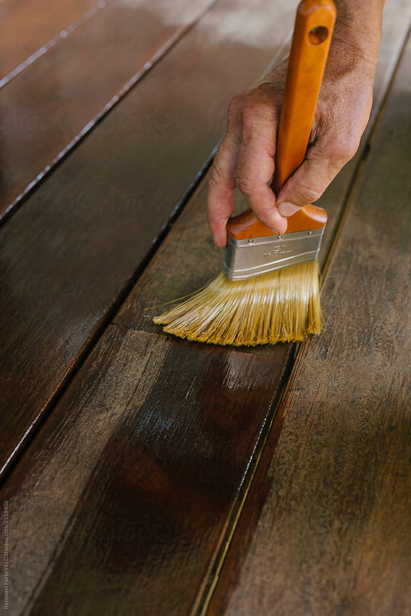 Close up of Hand applying Deck Stain