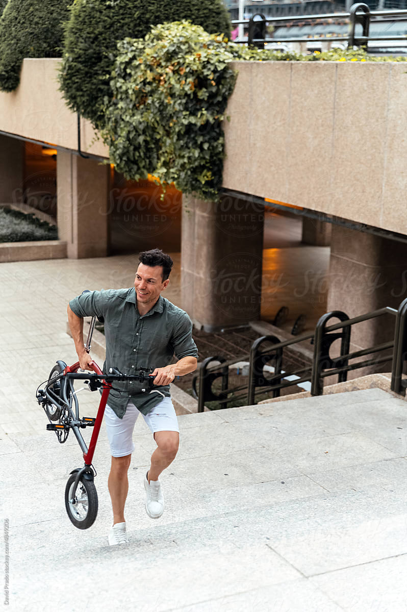 Man with electric bicycle walking on stairs