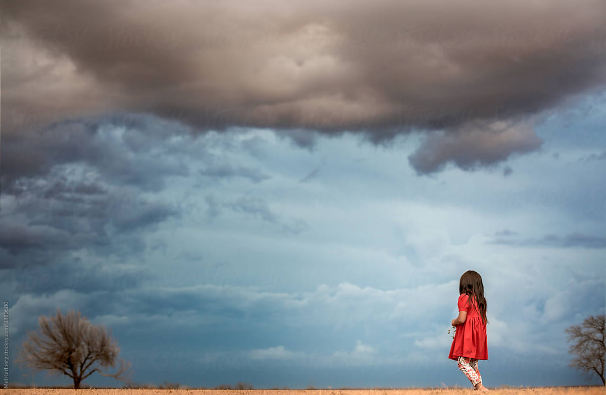 Girl watching storm clouds roll in