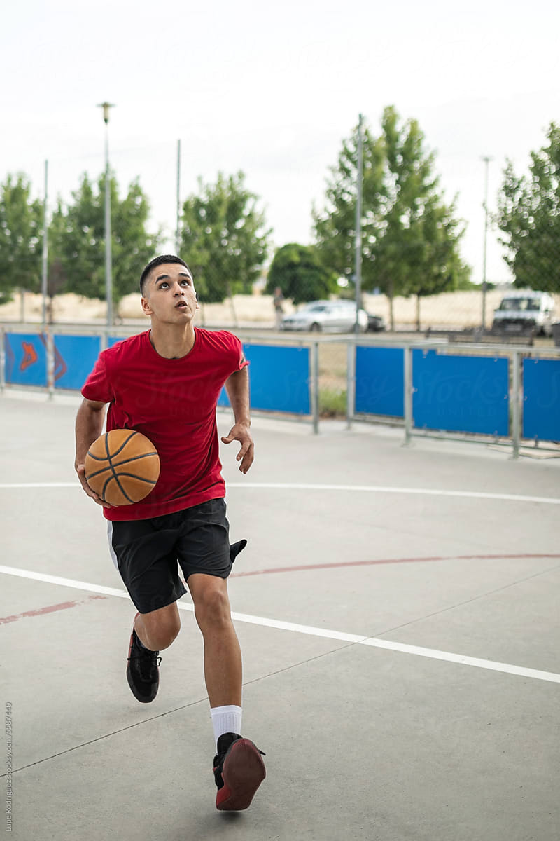 teenage boy playing basketball