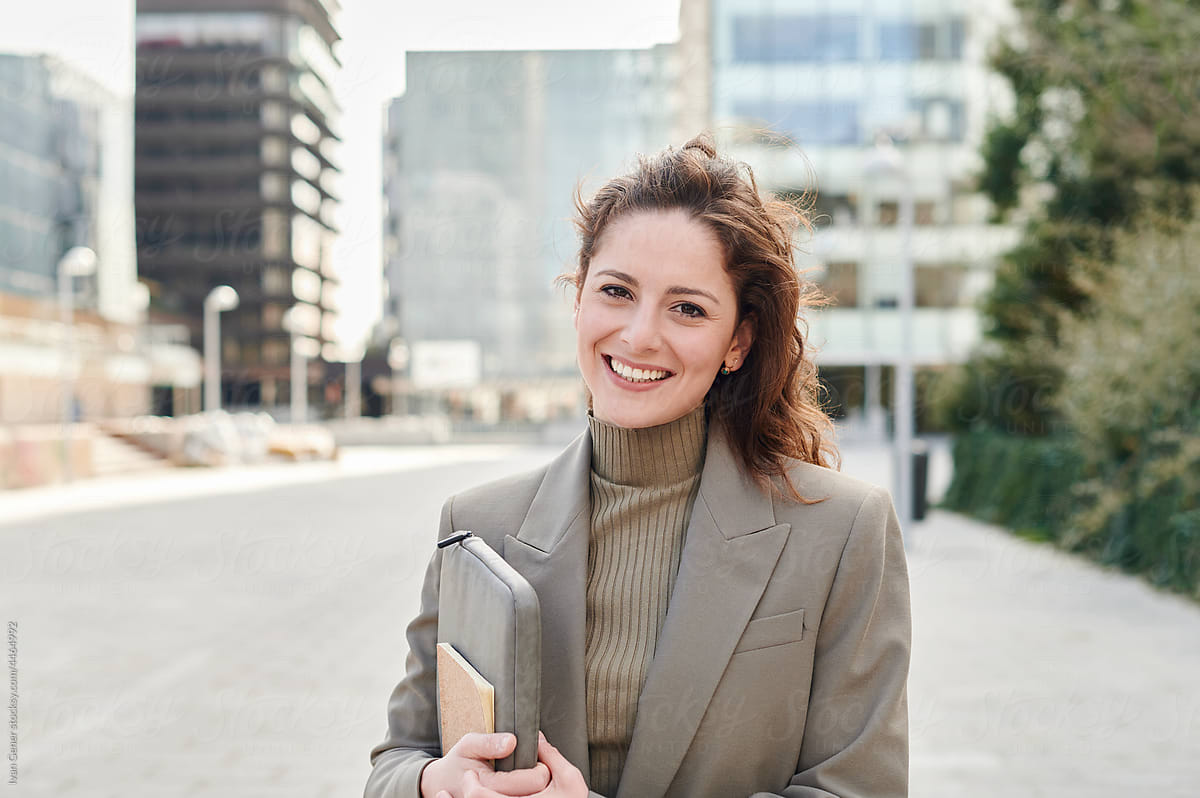 Smiling young businesswoman standing outside