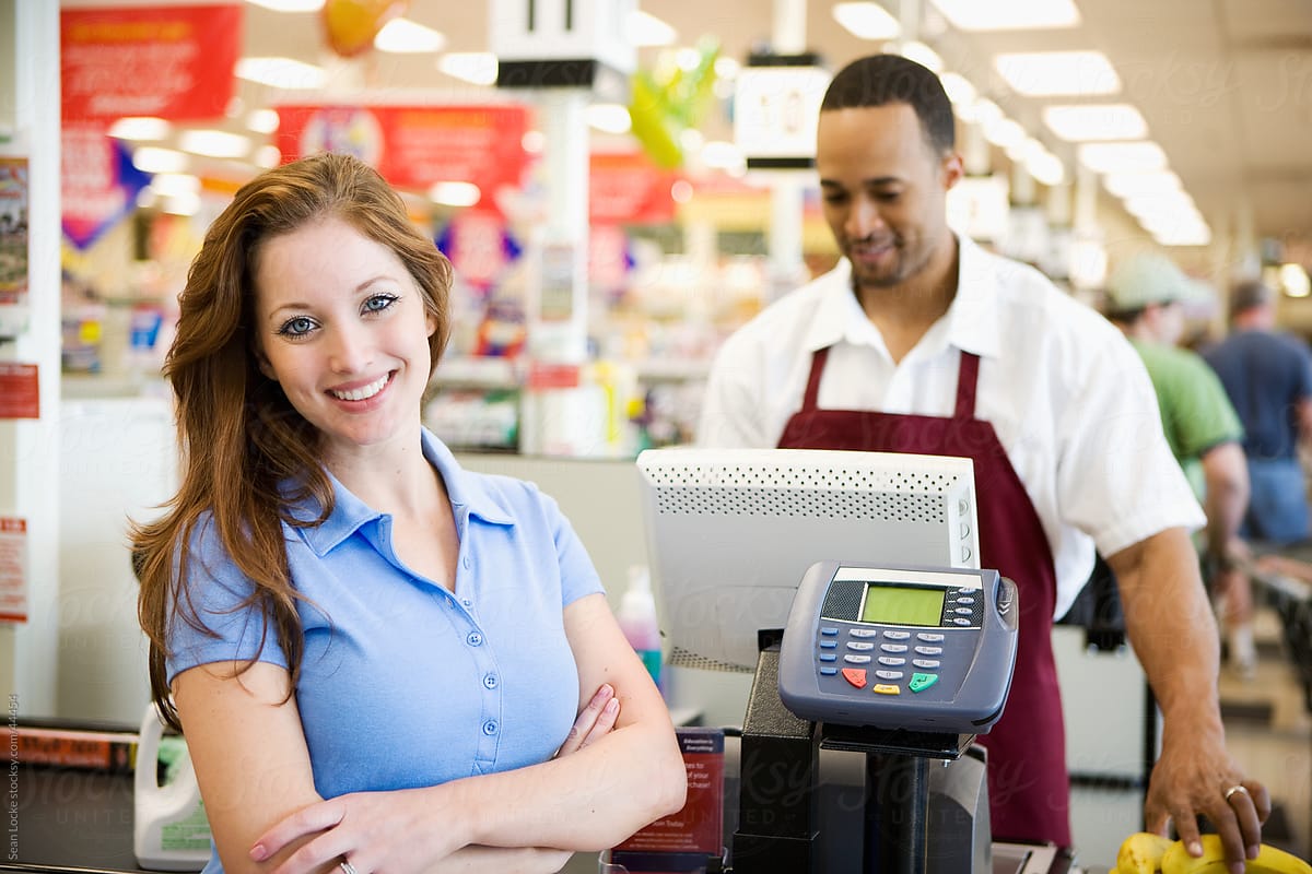 Supermarket: Cheerful Woman At Checkout Counter
