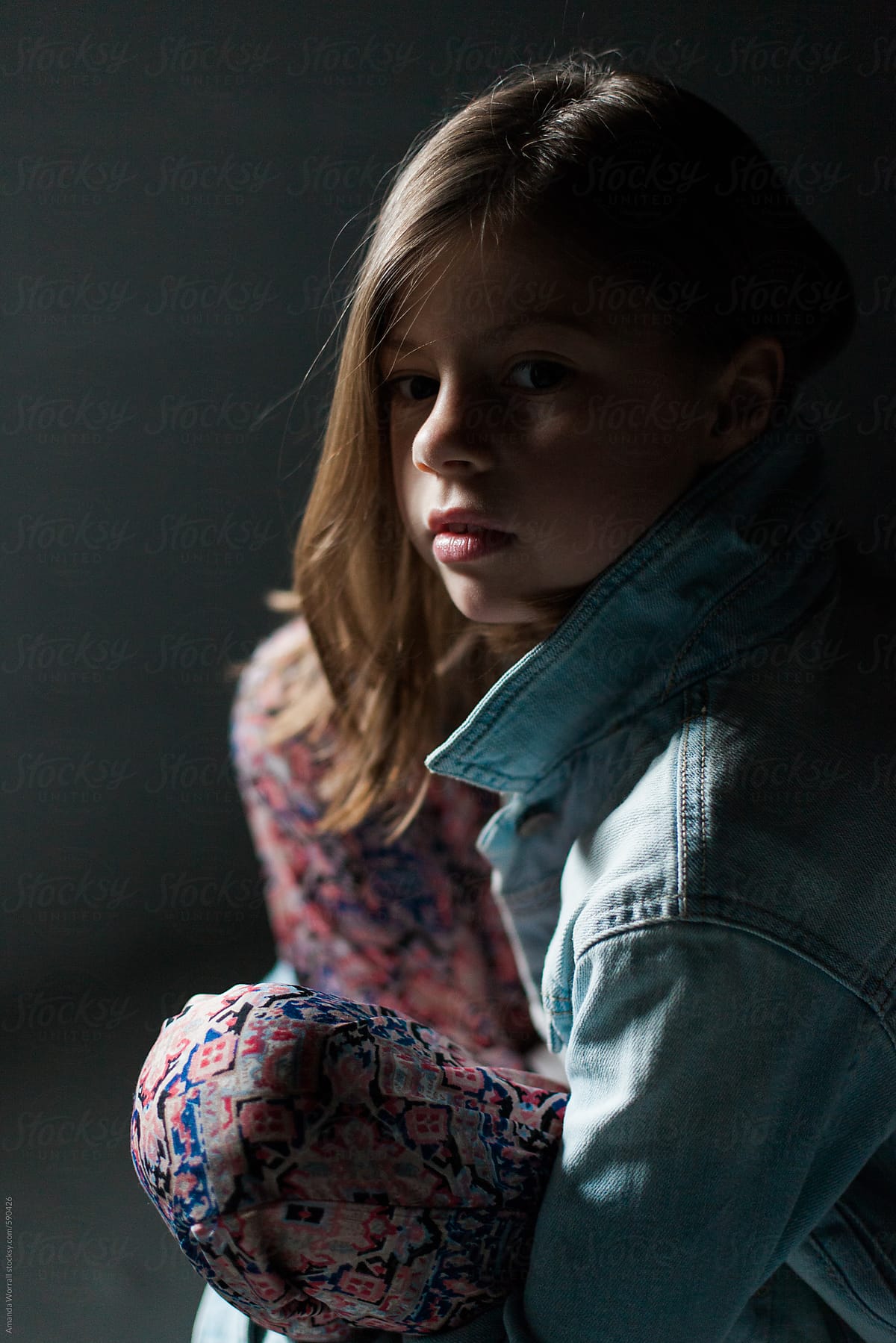 Pretty Young Girl Sitting In Dramatic Light By Amanda Worrall Stocksy United