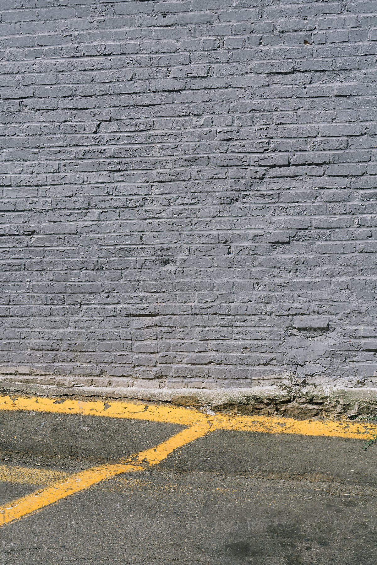 Detail o parking lot and painted grey brick wall