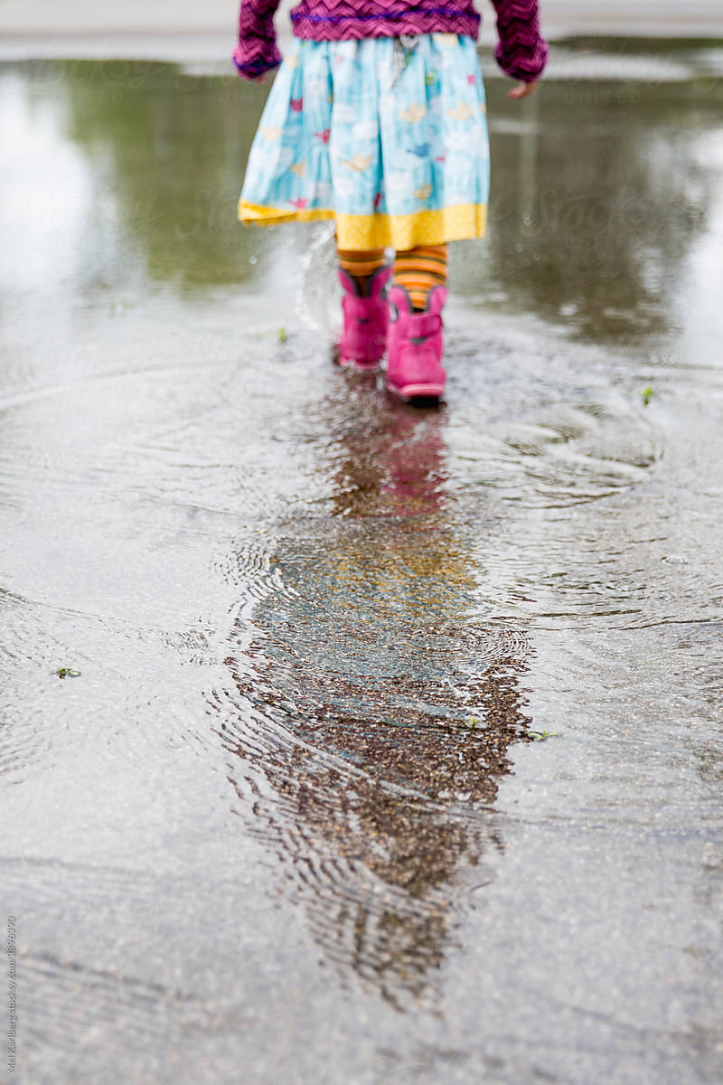 Girl\'s reflection in rain puddle