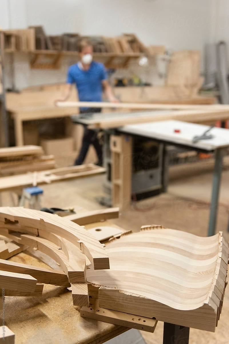 Hand crafted furniture in workshop, carpenter in background