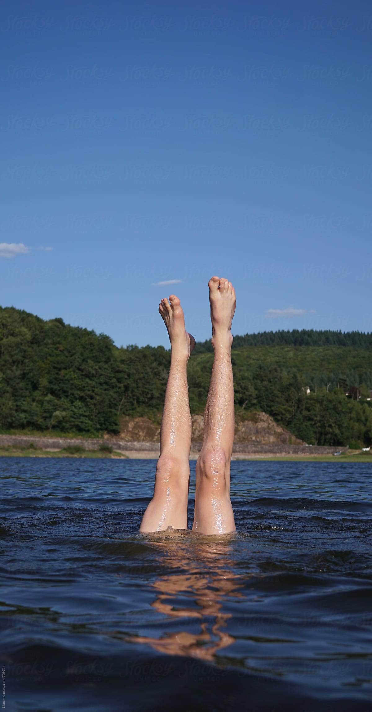 Young man upside down in the lake
