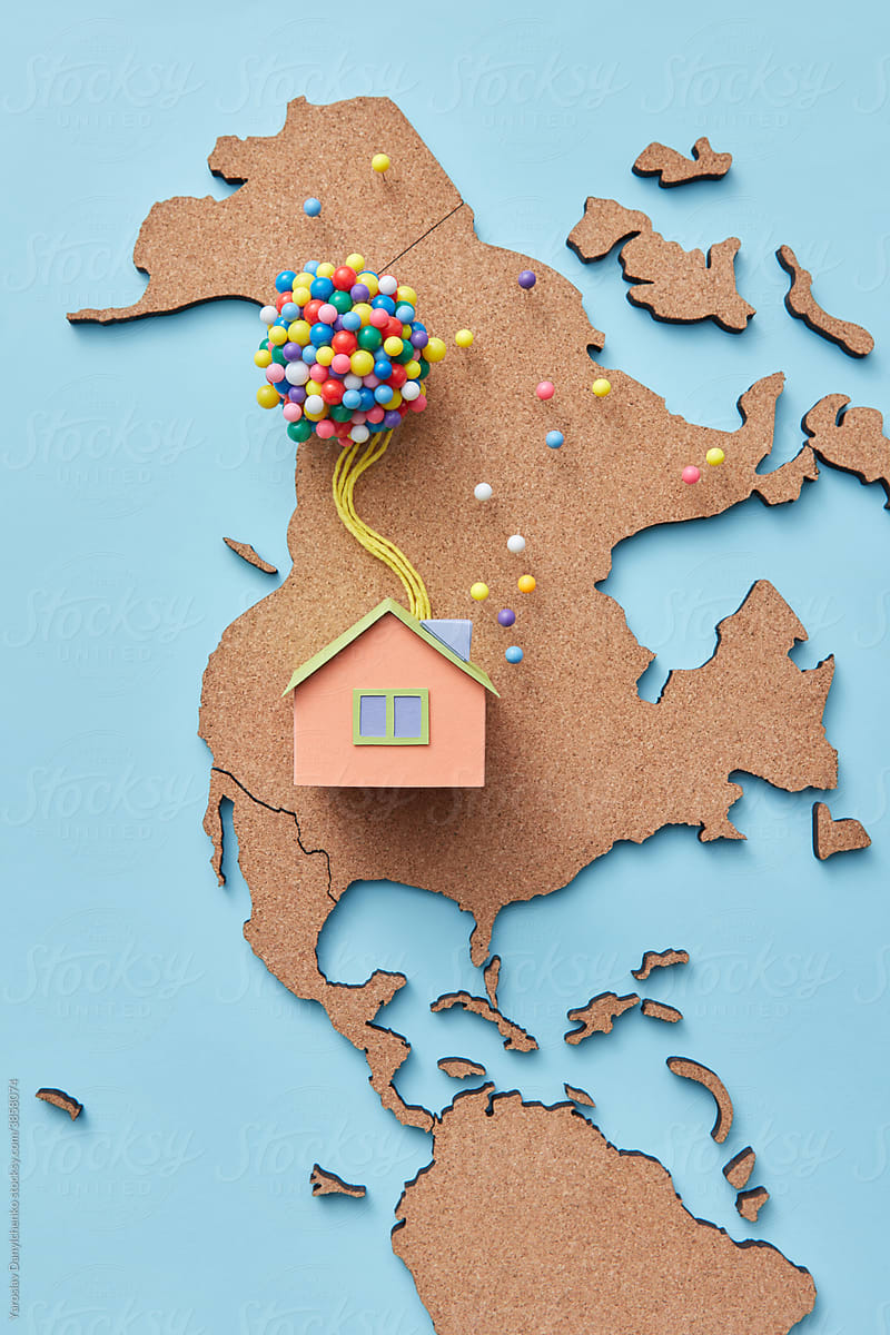 Beige papercraft house model with balloons on map