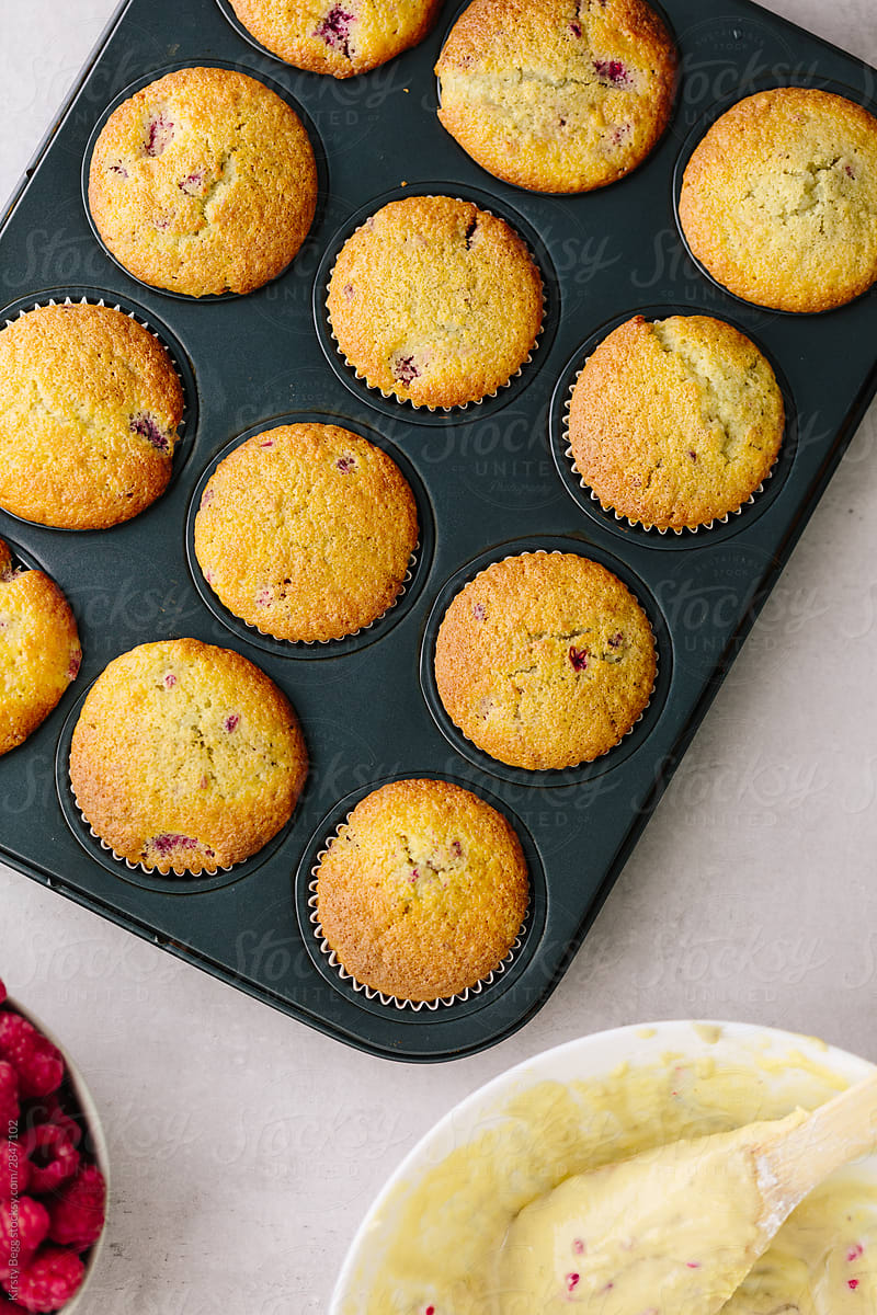 Baked raspberry muffins in cake liners in baking tin