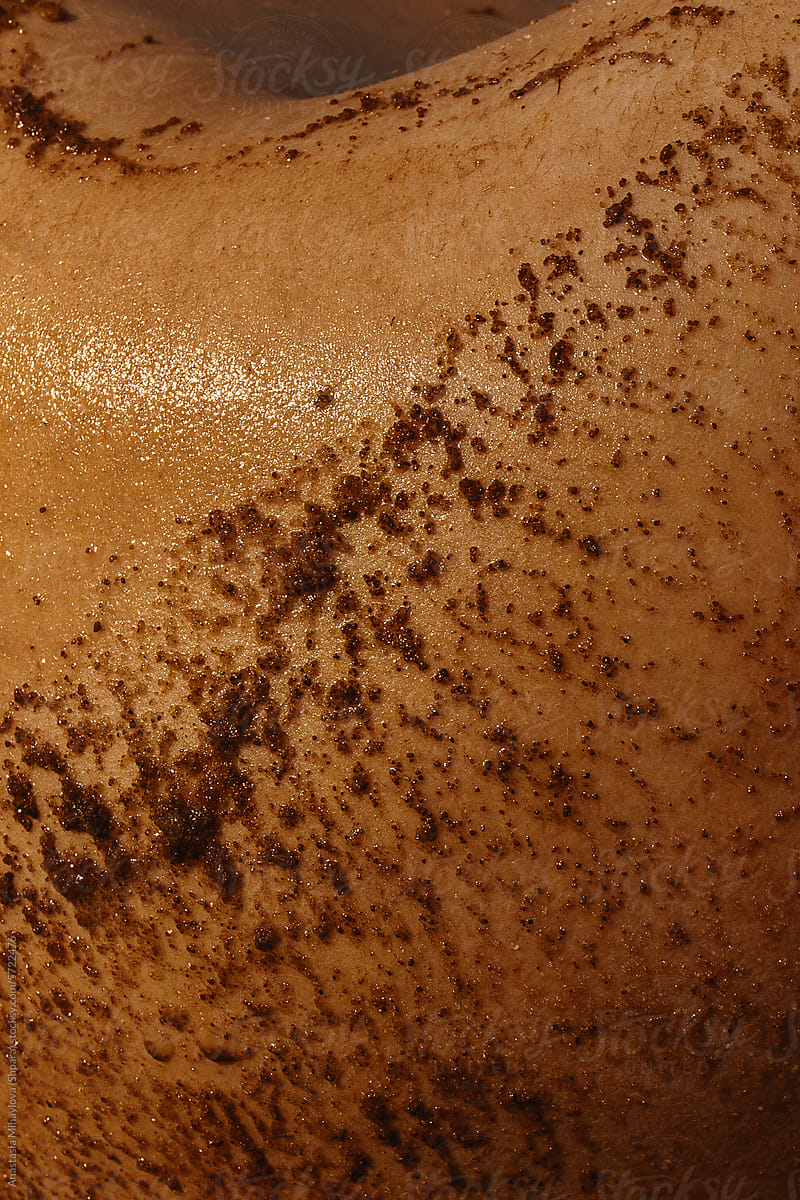 Close up photo of woman\'s skin texture of golden skin and scrub on it