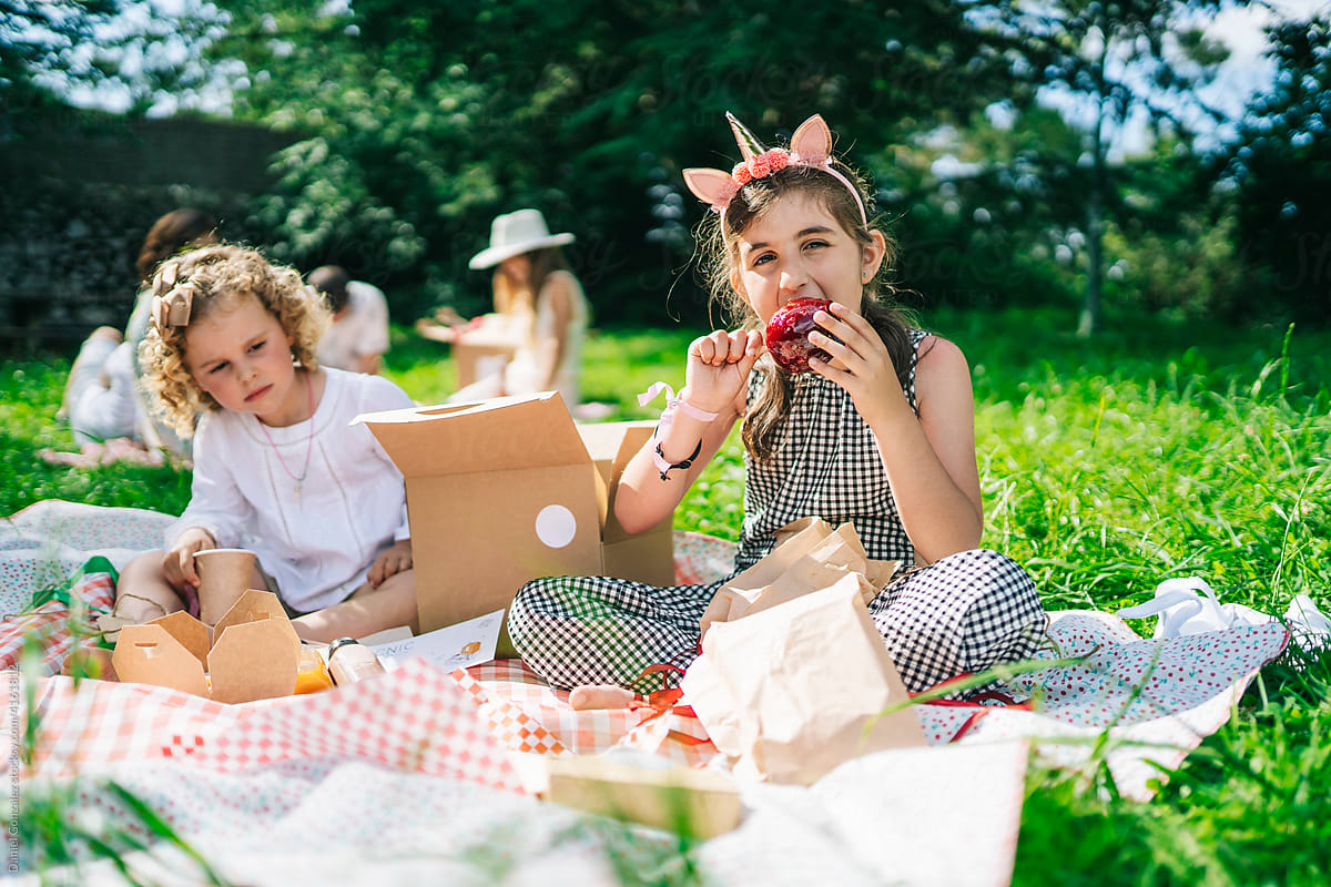 Positive children eating snacks during picnic