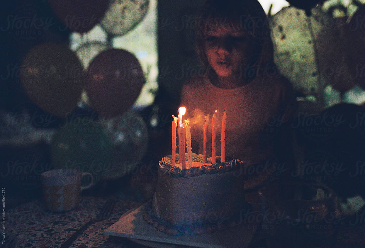 A girl blowing candles on her cake