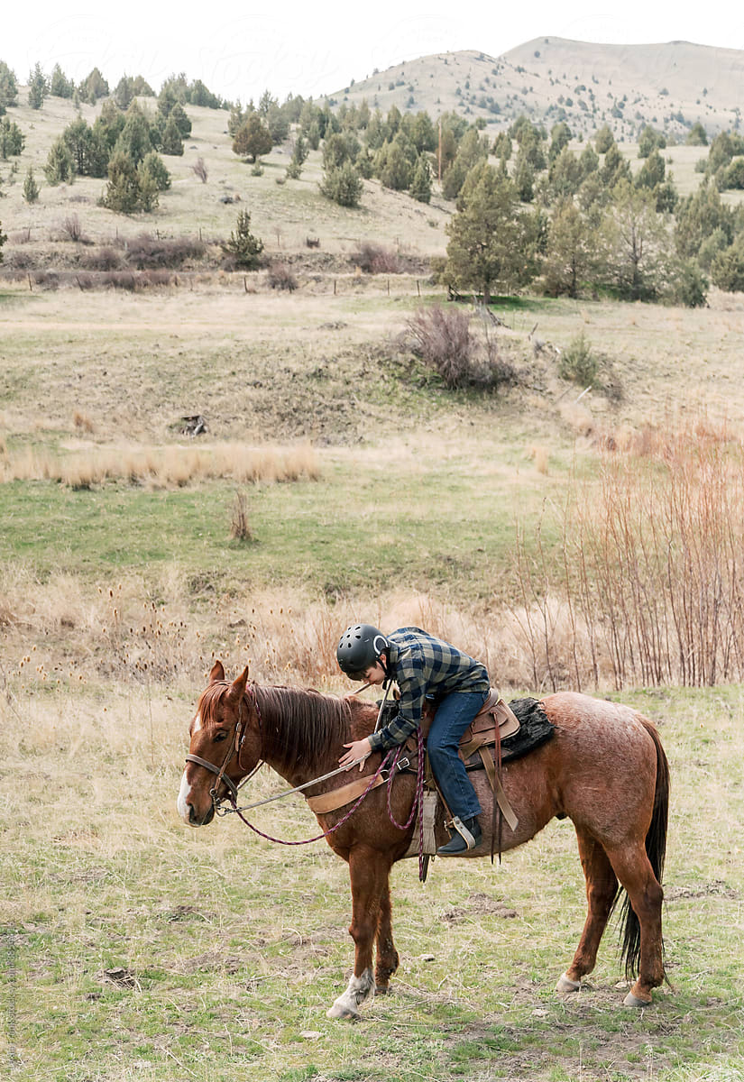 young cowboy pets his horse