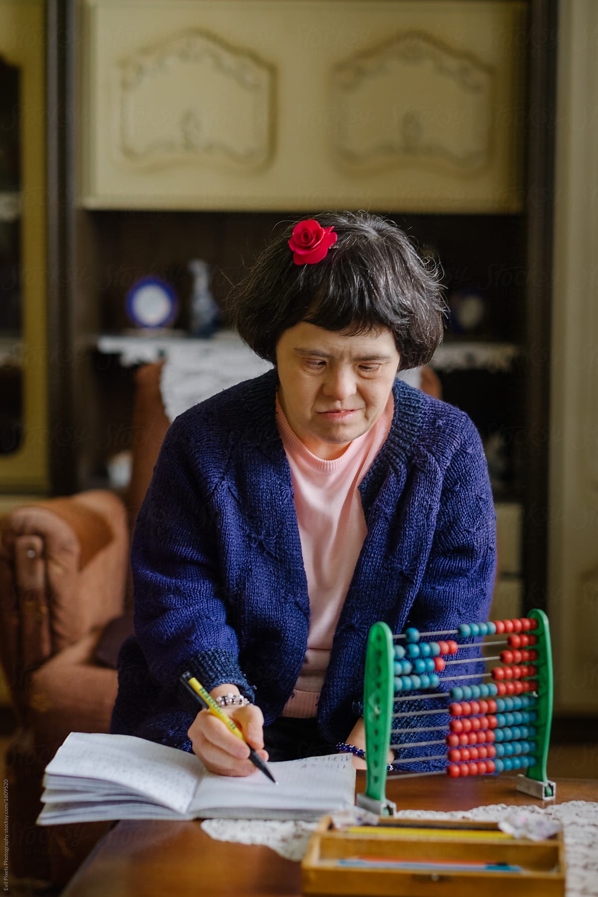 Woman With Down Syndrome Writing In A Notebook