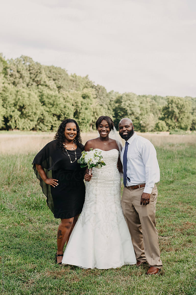 Bride Posed with Parents on Wedding Day