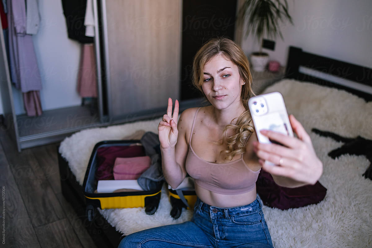 Female influencer photographing herself for travel blog