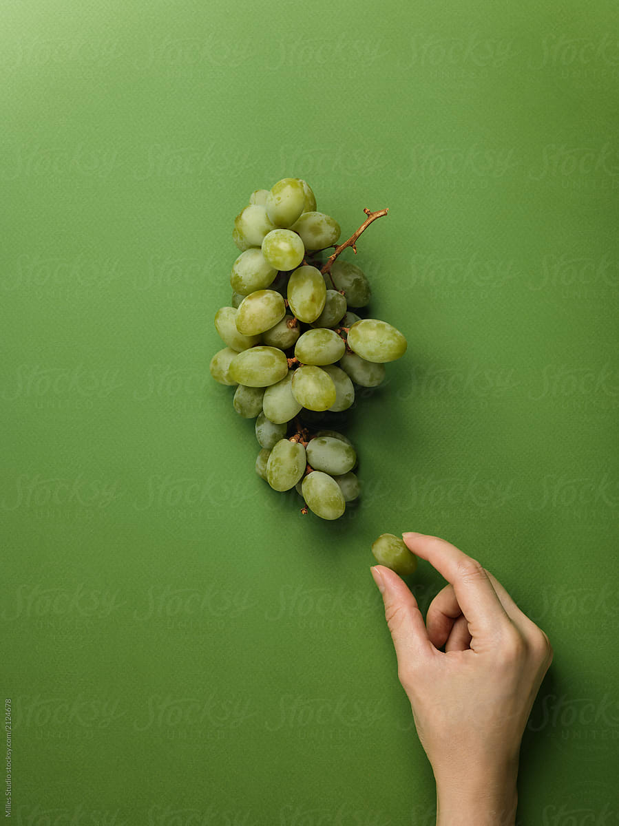 Crop hand with green grape