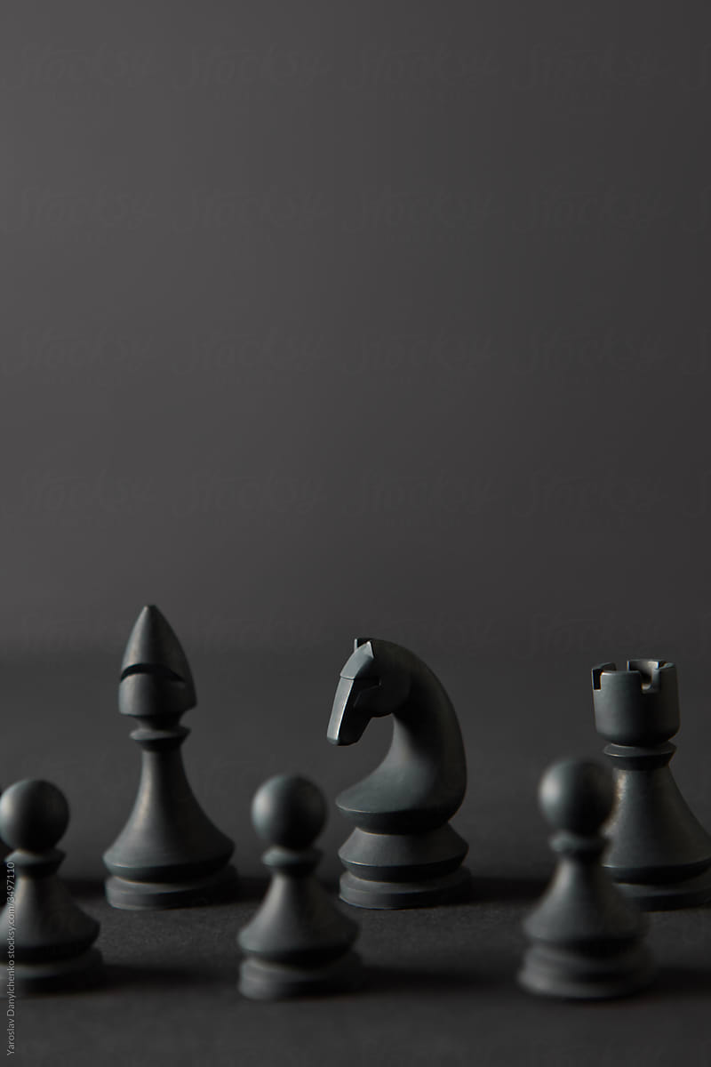 Set from black chess figures on dark background.
