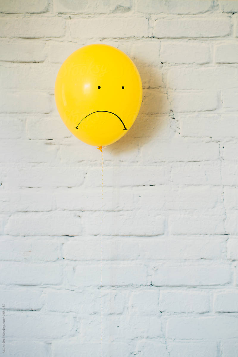 Sad faced yellow balloon looking down