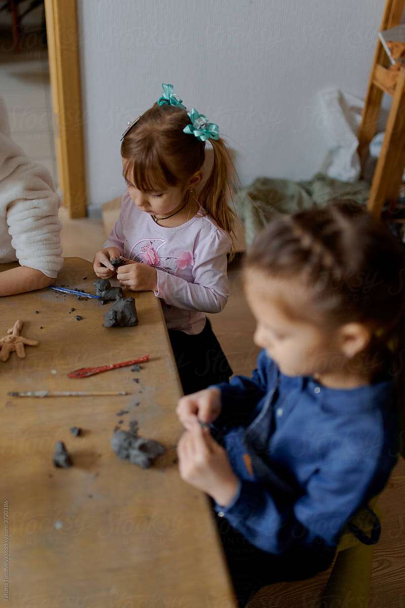 group of 5 year old preschool children in an art school learn to sculpt from clay