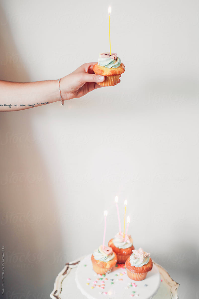 woman holding a birthday cupcake