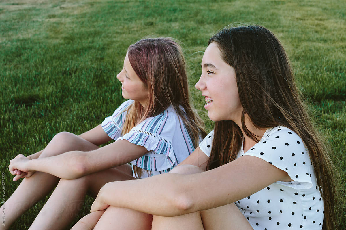 Young girls sitting on the grass smiling