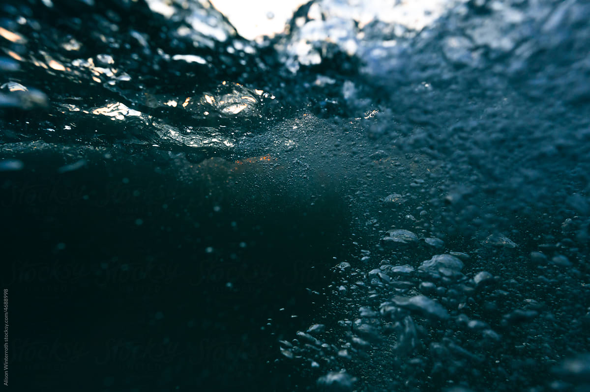 Bubbles rising to the surface of dark water