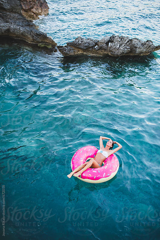 Woman Floating On Inflatable Tube In The Sea By Jovana Rikalo Stocksy 