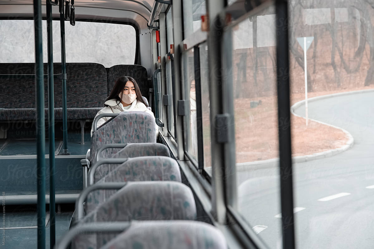 Asian woman riding bus on autumn street