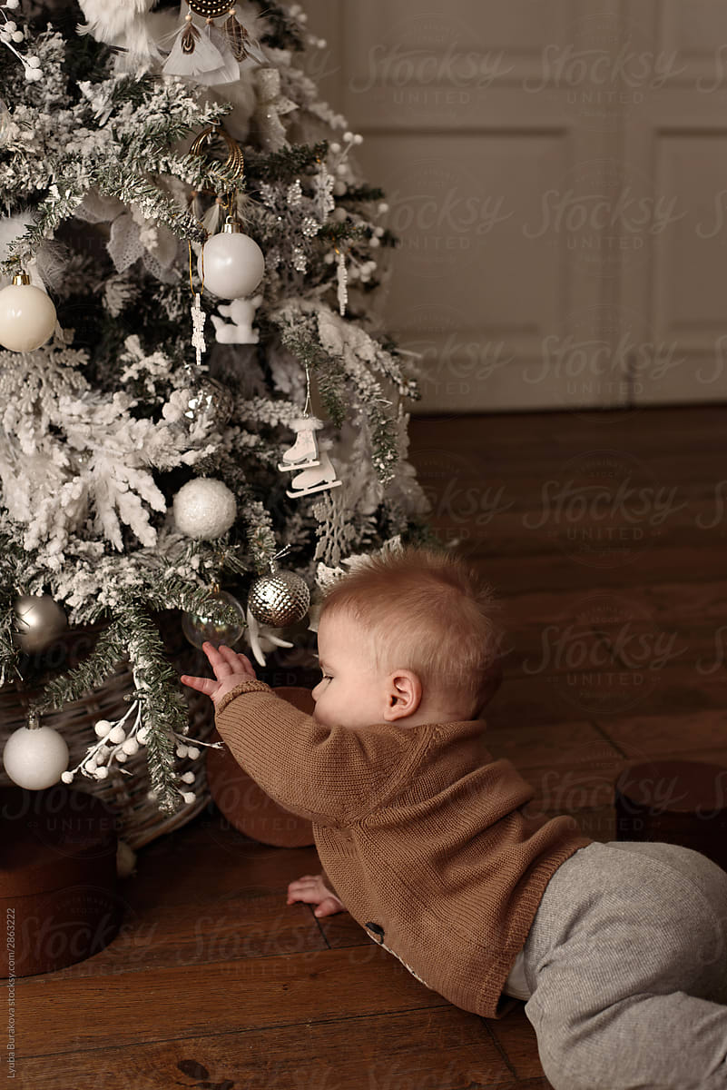 Baby boy playing with decoration of Christmas tree