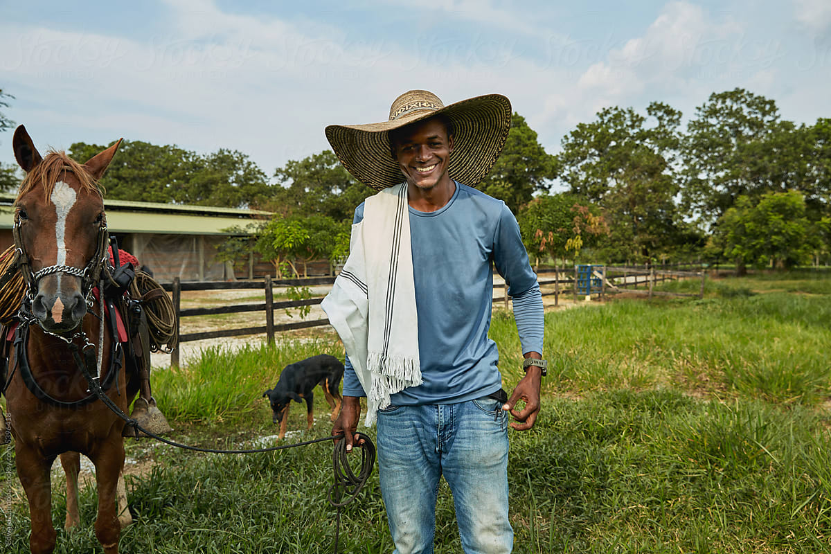 Young smiling farmer portrayed with his horse on a Colombian ranch.
