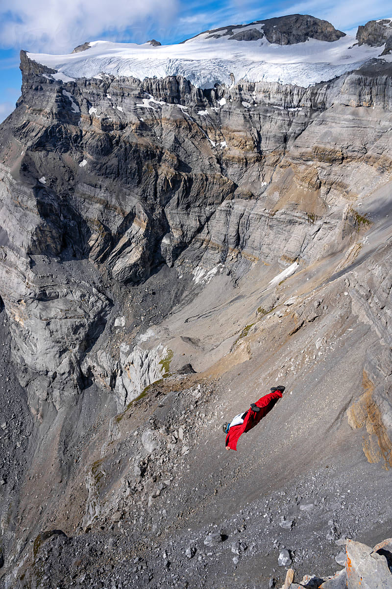 BASE jumper flying down the mountain cliff