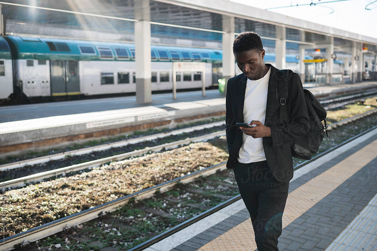 Young businessman using a mobile phone at train station