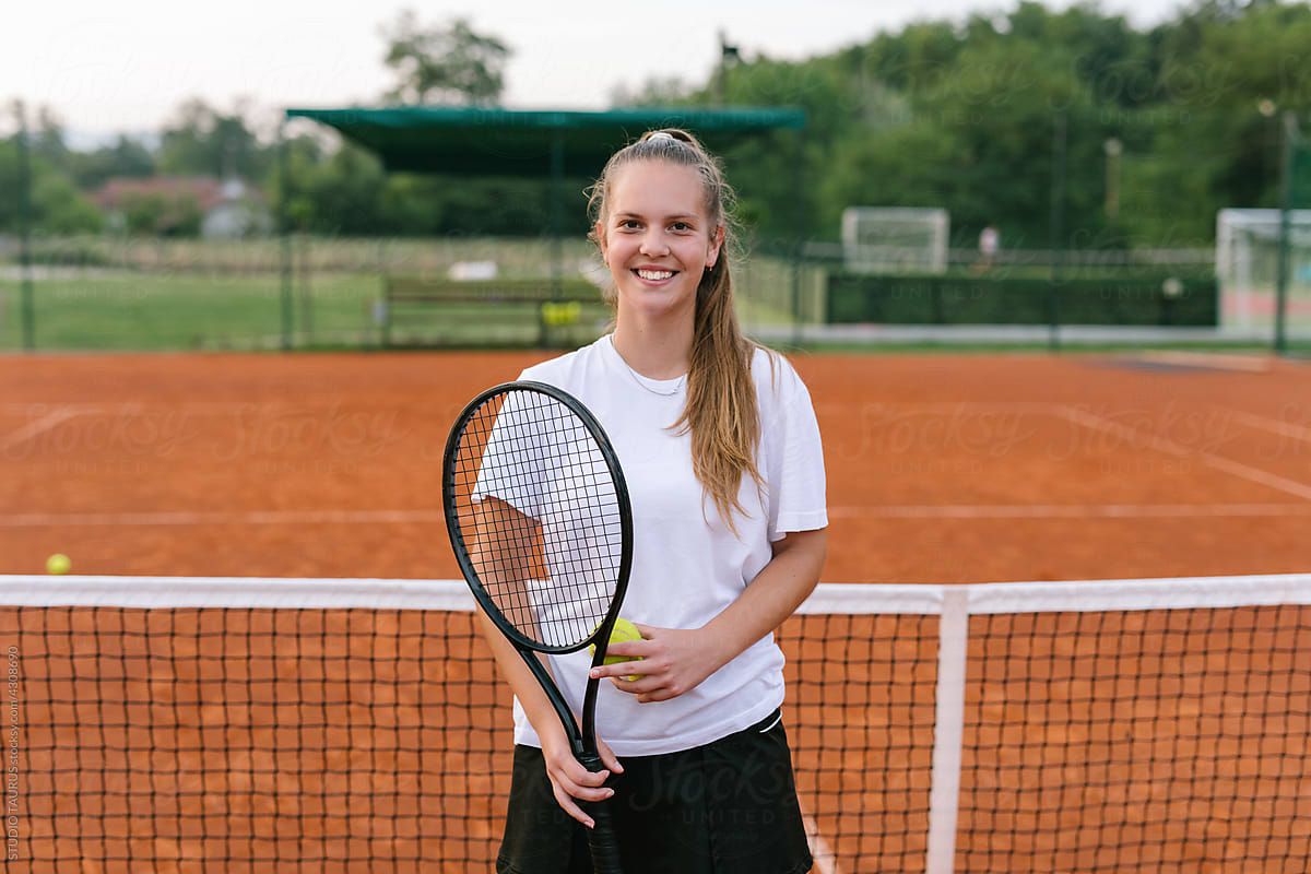 Young tennis player standing on a tennis court