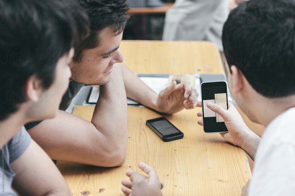 Group of Young Hispanic-Latino Men Having Fun Hanging Out Using Mobile Phone Device Technology