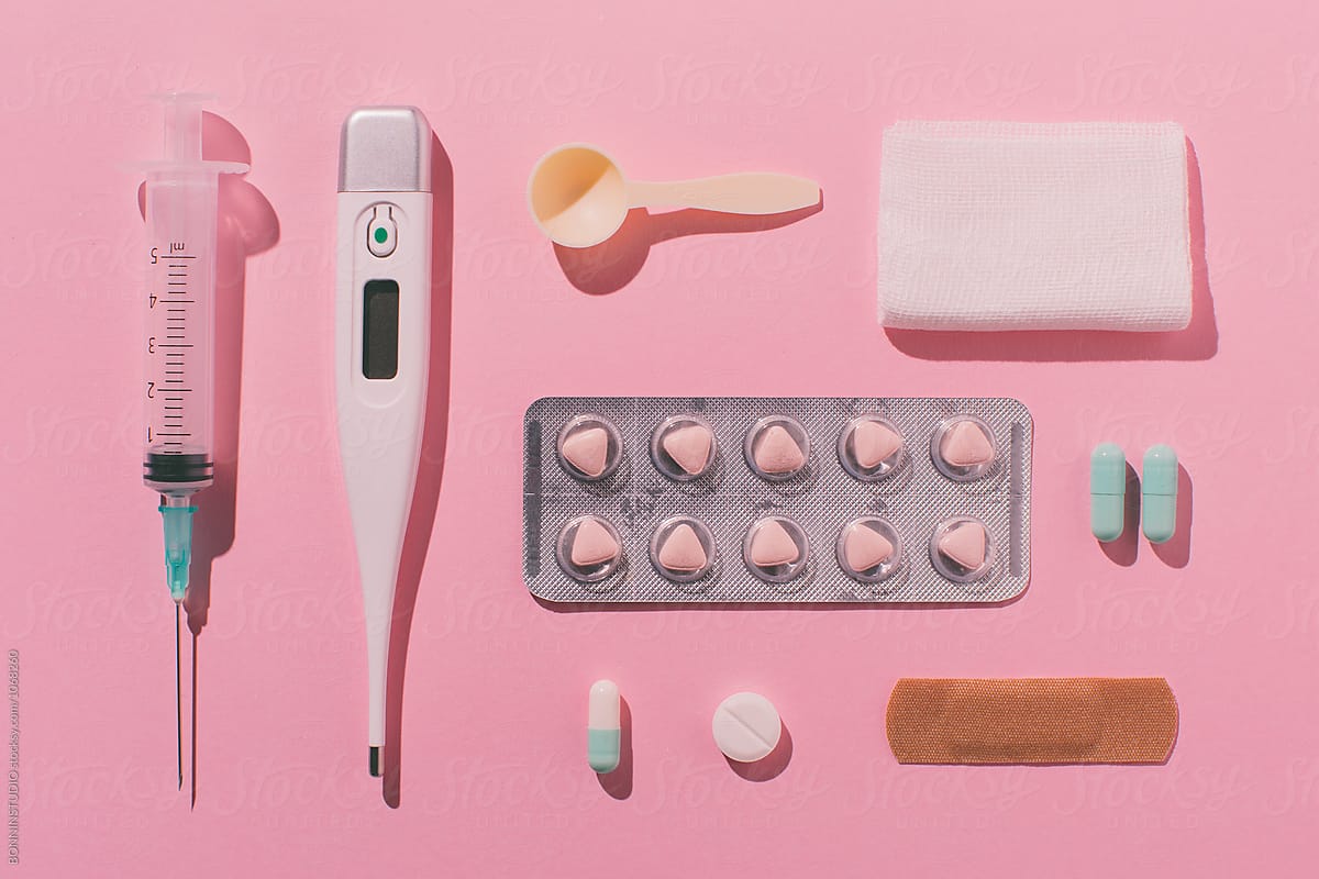 Still life of medical supplies on pink background.
