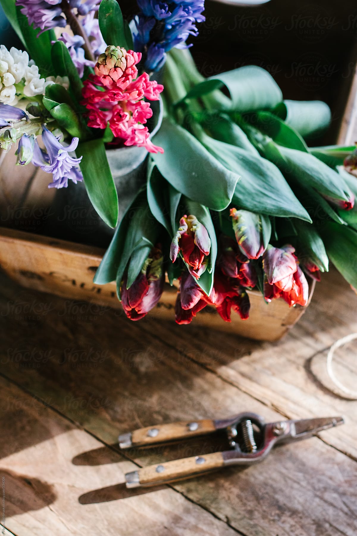 Red parrot tulips and hyacinths in a reclaimed wooden box.