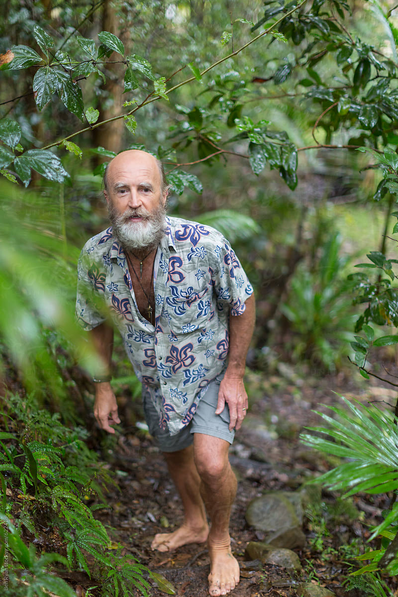 Alternative lifestyle senior male trekking barefoot in rainforest