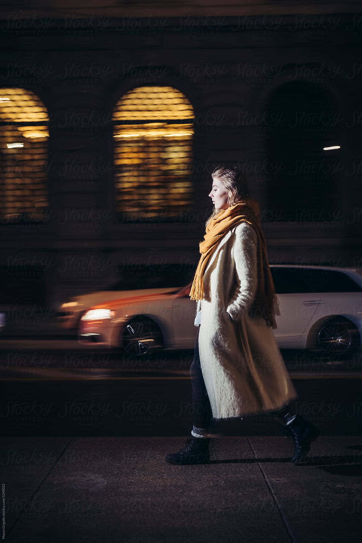 Woman walks alone in urban area at night