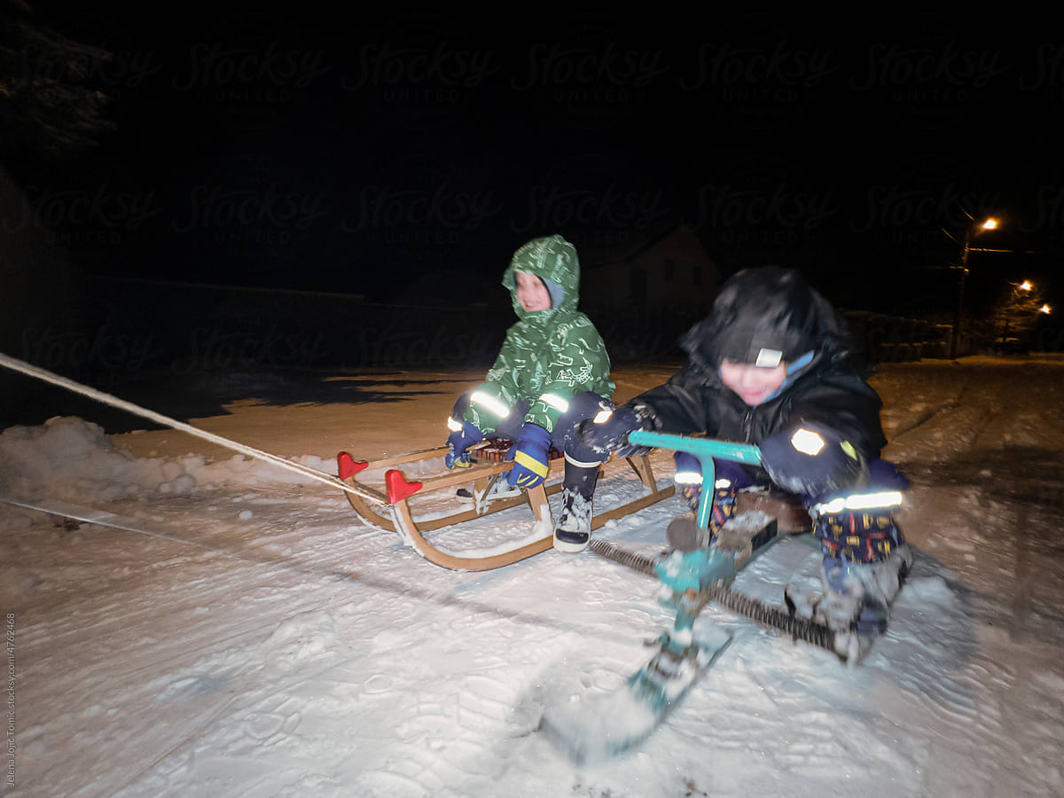 UGC kids excited on sleds during the winter night