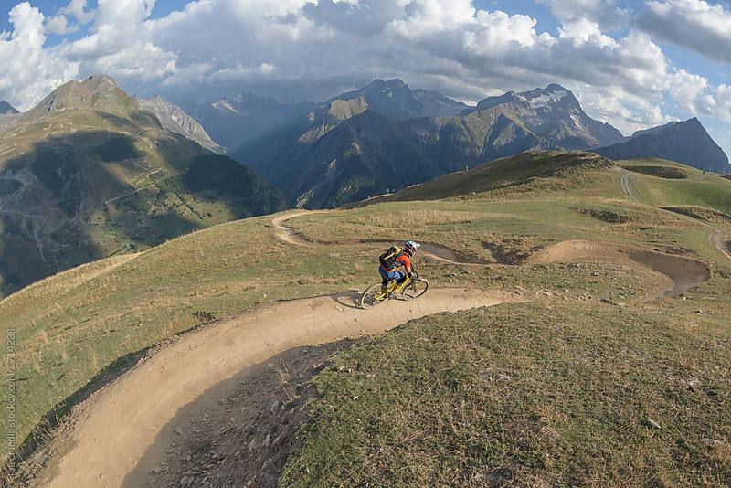 Male mountain biker freeriding downhill singletrack in staggering landscape