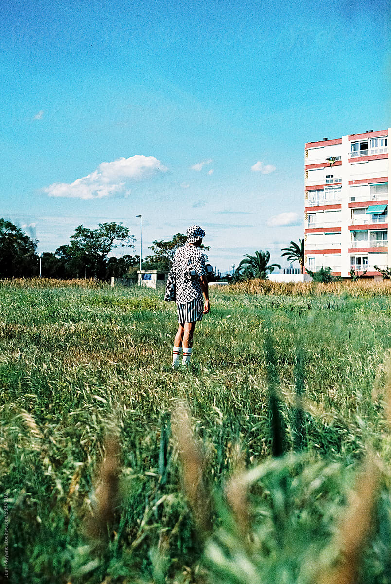 man standing in front of an apartment block, 35mm film