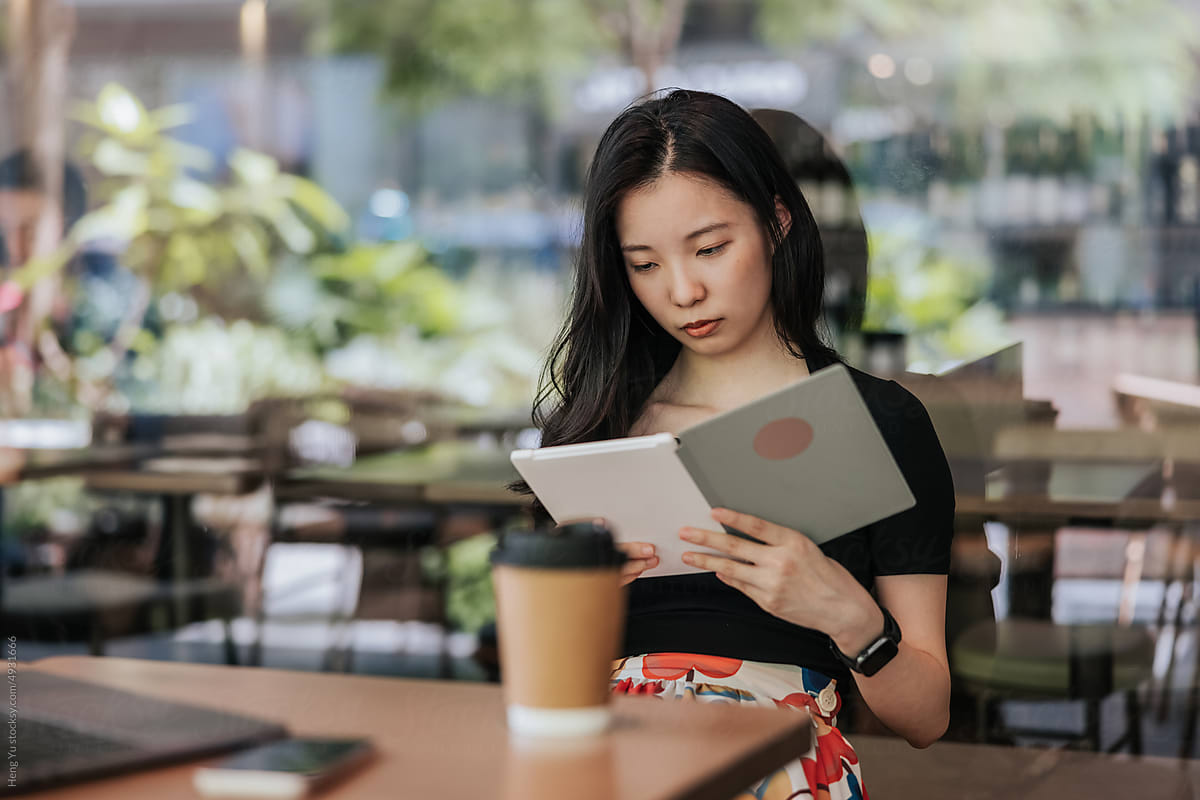 Young woman in a cafe reading an ebook